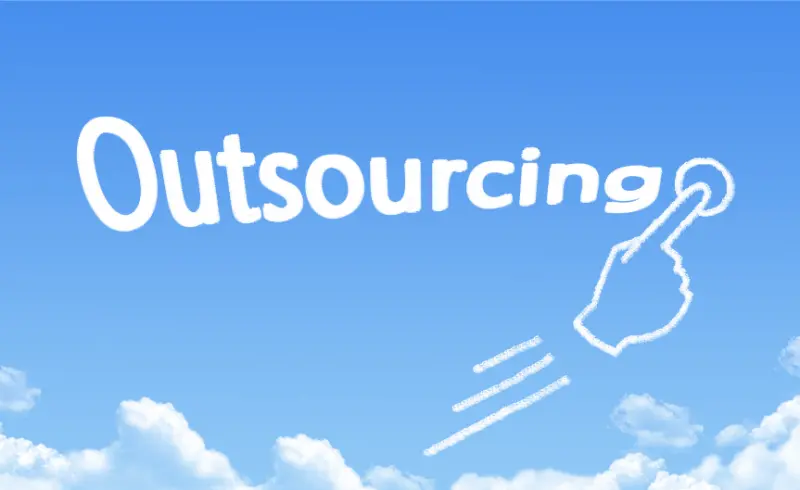 A hand-shaped cloud points to the word "Outsourcing" written in white against a bright blue sky with fluffy white clouds.