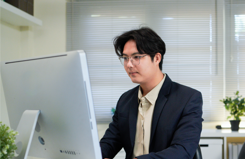 Man in glasses working at a desktop computer