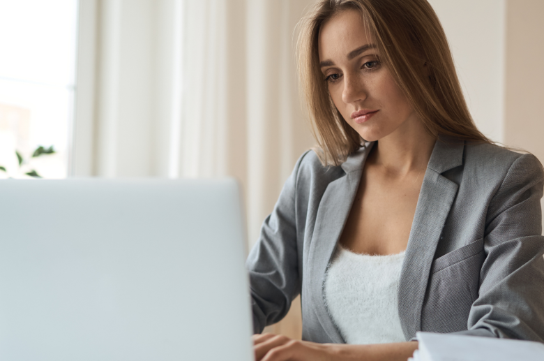 Woman in a blazer working on a laptop