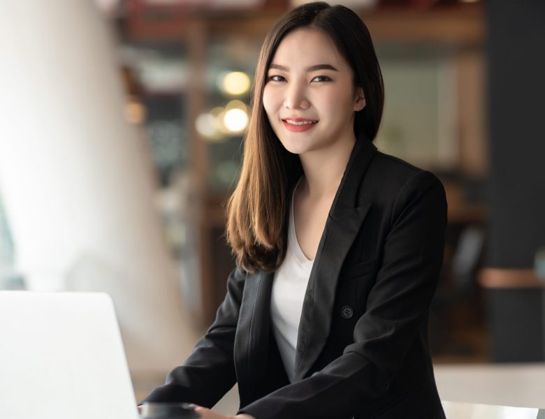 Smiling woman in a blazer at her desk