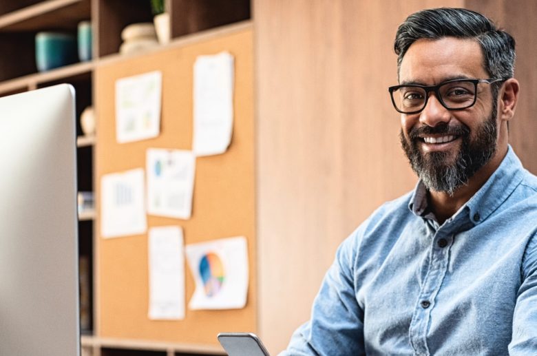 Smiling man in glasses at his desk