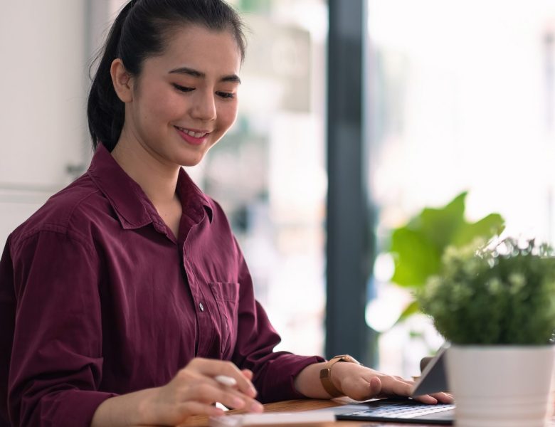 Smiling woman taking notes at her desk