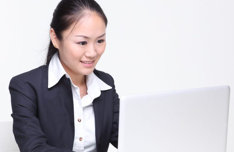 Woman in a blazer working at a laptop