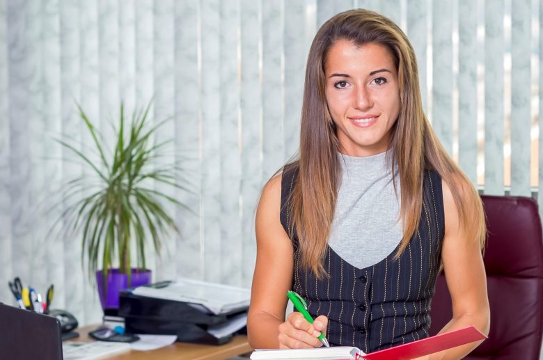 Smiling woman writing at a desk