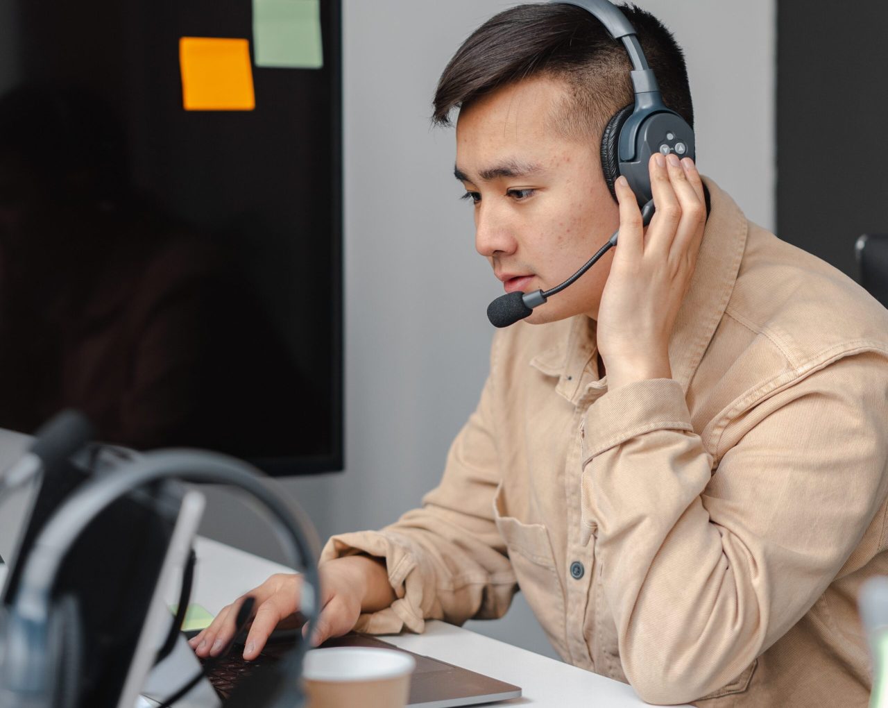 Man wearing a headset on a call at his desk