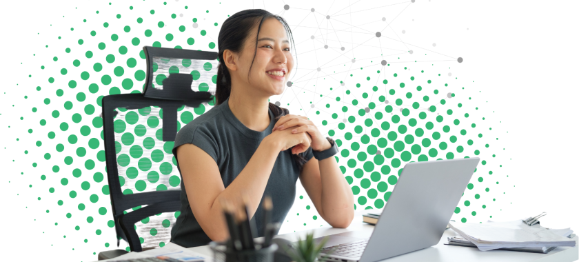 Smiling woman sitting at a desk with a laptop