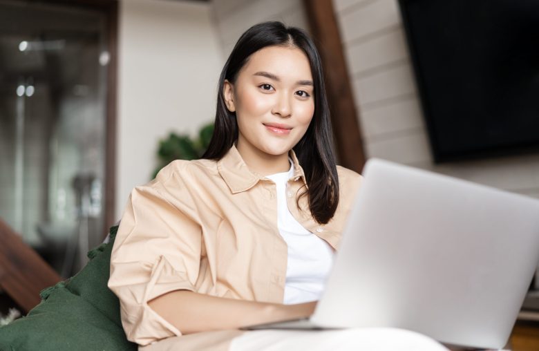 Smiling woman sitting with a laptop