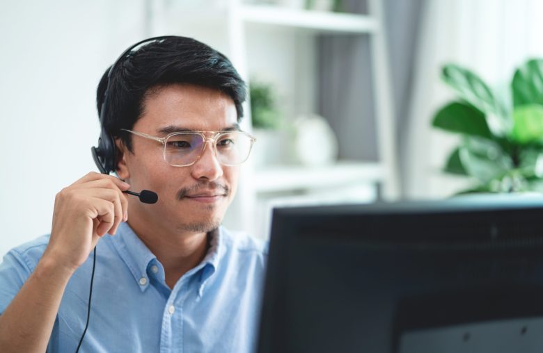Man wearing a headset on a call at his computer