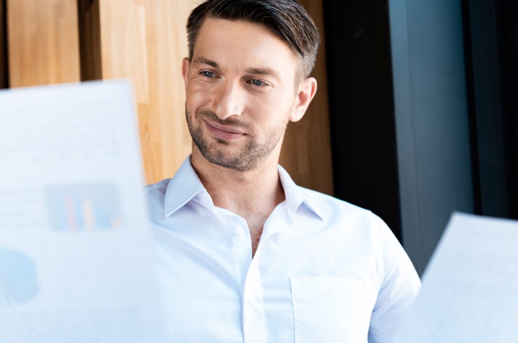 Man smiling while reviewing documents