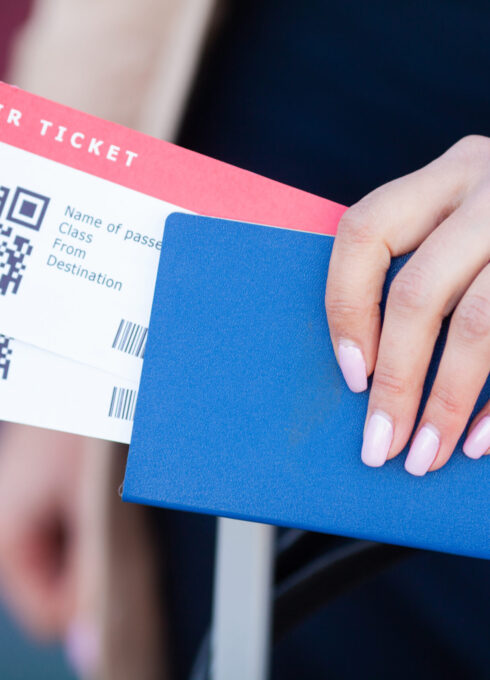 Travel. Closeup of girl holding passports and boarding pass at airport.