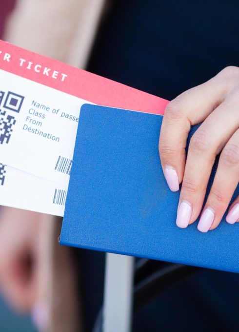 Travel. Closeup of girl holding passports and boarding pass at airport.